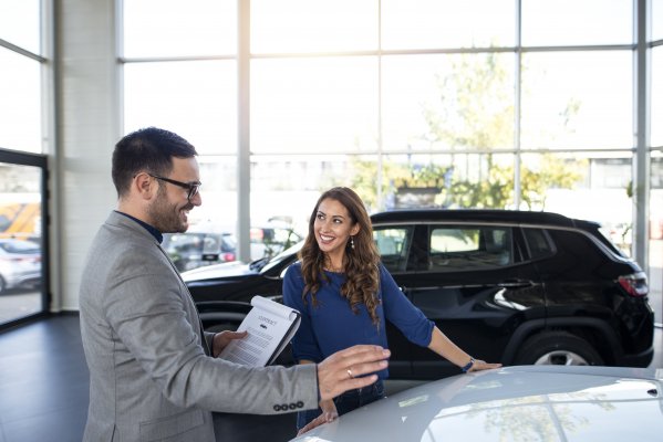 toco extended car warranty service happy woman and man in front of car signing car warranty